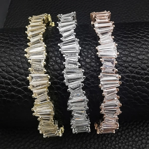 Close-up of three irregular baguette-cut zircon bracelets in gold, silver, and rose gold