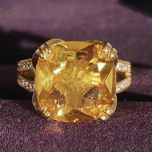 Lussuoso anello d'oro con una grande pietra gialla quadrata e accenti di diamanti