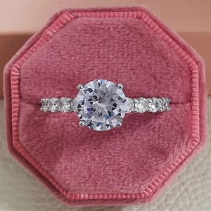 Macro detail of classic round-cut zircon engagement ring in a pink velvet jewelry box