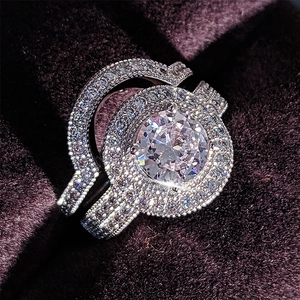Detalle macro de set de anillos de lujo con diamante redondo y pavé sobre fondo terciopelo