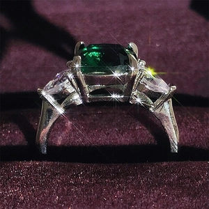Elegant silver ring with rectangular emerald-cut green stone and side teardrop crystals