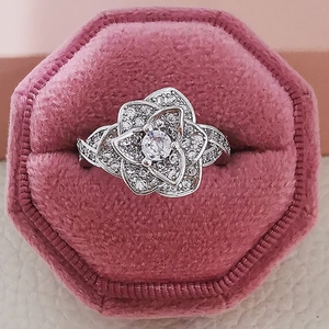 Elegante anillo en forma de rosa con circonitas en un joyero de terciopelo rosa