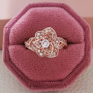 Elegante anillo de flor en oro rosa con circonitas en un joyero de terciopelo rosa