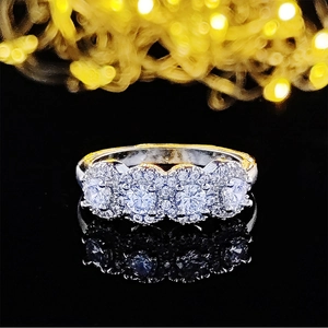 Vista macro de un anillo de plata con cuatro diamantes agrupados sobre fondo negro elegante