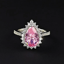 Makroaufnahme von Birnen-geschliffenem rosa Edelsteinring mit Halo-Diamant-Besatz