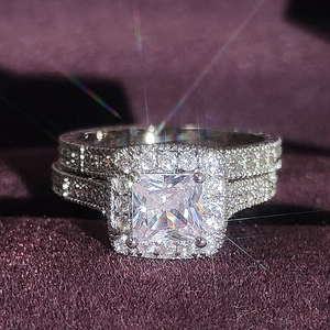 Set di anelli nuziali in argento con diamante a taglio princess su velluto viola scuro