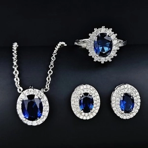 Detailansicht eines silbernen Schmucksets mit ovalen blauen Steinen und weißen Diamanten
