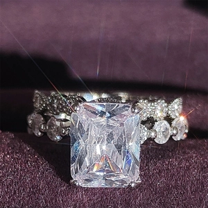 Luxury emerald-cut cubic zirconia wedding ring set on purple velvet background