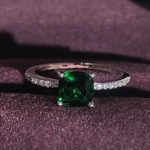 Elegant emerald-cut green gemstone ring with pavé-set zircons on silver band