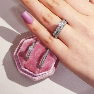 Detalle del lujoso juego de dos anillos con circón en una caja de terciopelo rosado