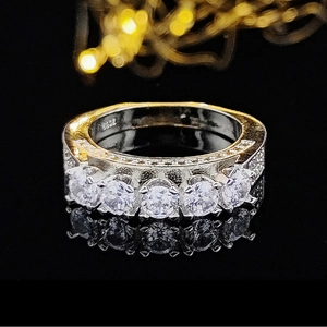 Detalle macro de anillo de plata S925 con cinco piedras redondas y detalles de pavé