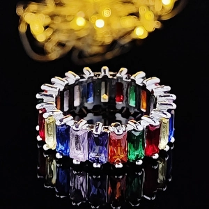 Classic rainbow eternity ring set with baguette cut gemstones in polished silver claw setting
