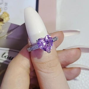 Elegant silver ring with a large heart-shaped purple gemstone and sparkling side stones