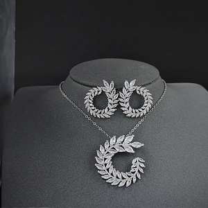 Elegant silver jewelry set with white marquise cut stones in a wreath design on black stand