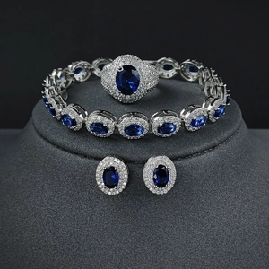 Three-piece silver jewelry set with oval blue gemstones and white diamond accents