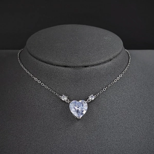 Elegant heart pendant necklace set with clear zircon stones on a dark jewelry display