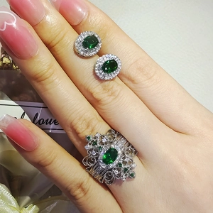 Vintage-Smaragd-Schmuckset bestehend aus ovalen Ohrsteckern und einem Halo-Ring