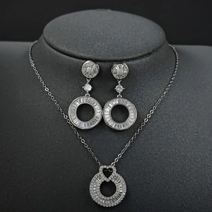 Irregular round geometric jewelry set featuring silver pendant necklace and hoop earrings
