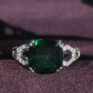 Dettaglio macro di anello vintage in argento con pietra verde e filigrana a cuore