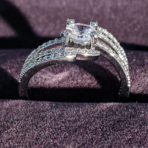 Elegante anillo de circonita multicapa con piedra central redonda en caja de terciopelo