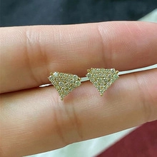 Macro shot of triangle stud earrings with 18K rose gold finish and pavé cubic zirconia