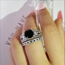 Close-up of a vintage luxury ring set with a cushion-cut black gemstone and silver band