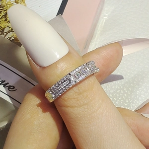 Detalle del anillo de lujo plateado con filas de circonitas y piedra rectangular