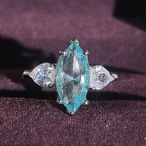 Detalle macro de un anillo clásico con piedra azul marquesa y detalles de pera