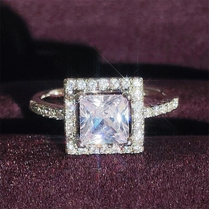 Detalle macro de un anillo halo con diamante cuadrado en estuche de terciopelo y pavé