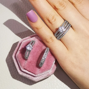 Primer plano del conjunto de anillos de lujo con piedra principal redonda y bandas pavé
