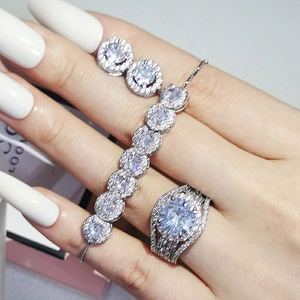 Luxury silver-tone jewelry set featuring a large round diamond ring and shimmering chain bracelet