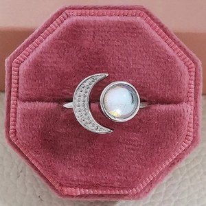 Detail of moonstone ring with sparkling crescent design in a pink velvet jewelry box
