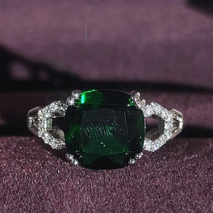 Macro de un anillo de plata vintage con una gran esmeralda verde y circonitas engastadas