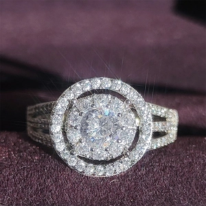Luxury halo engagement ring with round brilliant center stone and pave diamond band