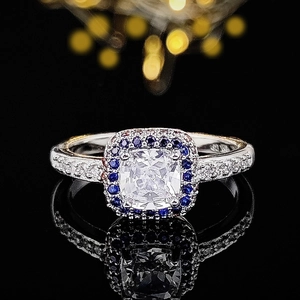 Halo ring with cushion cut zircon and blue stones on luxury polished silver band