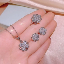 Detailed view of silver snowflake jewelry set with necklace, ring and stud earrings