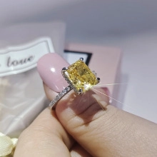 Primer plano de anillo con cristal amarillo rectangular y micro-pavé de diamantes en plata
