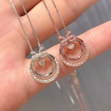 Detail of silver and rose gold bow necklaces featuring cubic zirconia and double-ring pendant