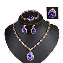 Dettaglio di un set di gioielli di lusso con pietre blu a forma di pera e corona regale