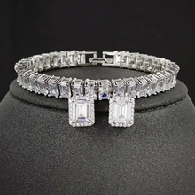 Detailed view of silver jewelry set featuring emerald-cut cubic zirconia in claw settings