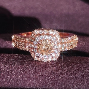 Luxurious 14k rose gold ring with a champagne center stone and double halo pavé setting