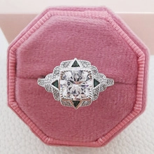 Macro view of a vintage Art Deco ring with square white zircon and green side stones