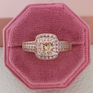 Luxurious 14k rose gold ring with champagne round stone in halo setting on velvet