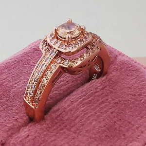 Macro view of a 14k rose gold ring with champagne center stone in pink velvet box