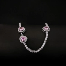 Detailed macro view of pink heart-shaped gemstones on a silver tennis chain bracelet