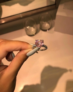 Detail of a pink heart-cut gemstone ring with micro-pave diamond accents on the silver band