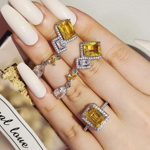 Elegant jewelry set with yellow emerald-cut stones in a geometric silver-tone ring and earrings