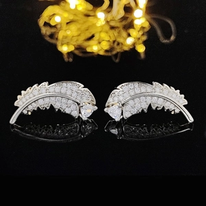 Orecchini a piuma in argento con zirconi pavé e pietra a cuore su sfondo nero riflettente