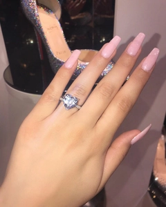 Close-up of heart-shaped crystal ring with micro-pave diamonds on model's finger