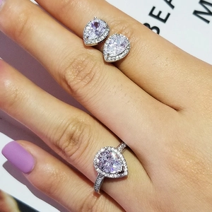 Set gioielli a goccia con anello e orecchini halo indossati su mano per donna
